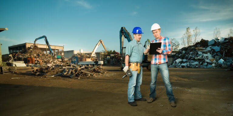 Two team members reviewing material inventory at a scrapyard